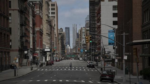 A cyclist rides his down the middle of a main road in downtown New York, on Sunday, March 22, 2020. New York City accounts for roughly 5% of the around 380,000 cases worldwide, with more than half the 20,000 cases reported in New York state. The increase in numbers is reflection of the increase in tests being conducted, state officials have said and not necessarily of the spread of the virus. (Wong Maye-E / AP)