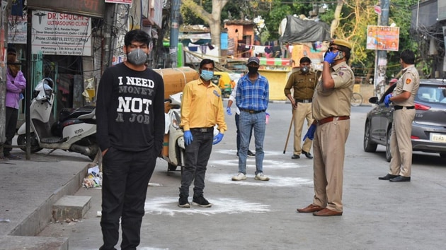 Delhi Police personnel ensuring that shoppers stand at designated places outside a grocery store. (Raj K Raj) Delhi Police personnel ensuring that shoppers stand at designated places outside a grocery store. (Raj K Raj)