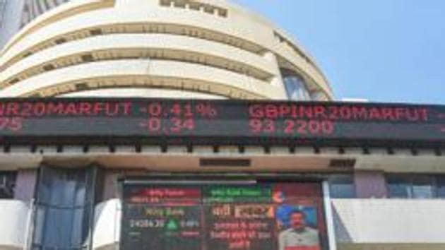 A  man wears a mask and walks past the BSE building in Mumbai.