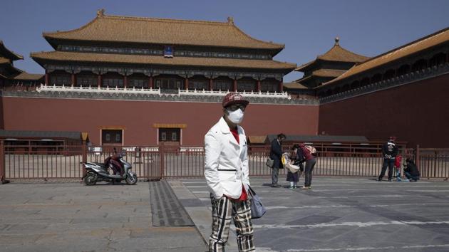 A visitor stands in front of the shuttered Forbidden City in Beijing. Travel and tourism are major employers in Beijing, and like all service industries, have been hard-hit by the outbreak and accompanying closure orders. Schools, including famed institutions such as Peking University, remain closed, and authorities say it may be weeks or longer before students can return to classrooms. (Ng Han Guan / AP)