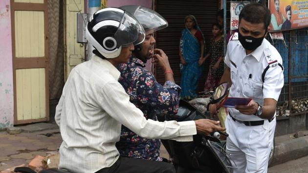 A policeman check the identity of people out during lockdown due to coronavirus outbreak, in Kolkata, West Bengal, on Tuesday, March 24, 2020. (Samir Jana / HT Photo) A policeman check the identity of people out during lockdown due to coronavirus outbreak, in Kolkata, West Bengal, on Tuesday, March 24, 2020. (Samir Jana / HT Photo)