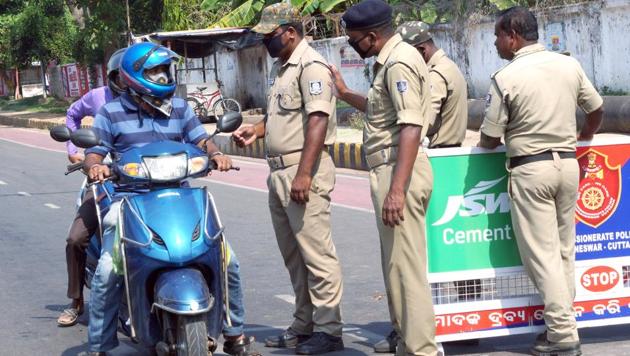 Policemen in Bhubaneswar stop a two-wheeler for violating the lockdown . (ANI) Policemen in Bhubaneswar stop a two-wheeler for violating the lockdown . (ANI)