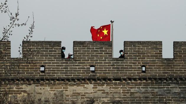 Security guards wearing protective face masks stand watch on the Badaling Great Wall of China. Authorities are limiting access to avoid crowds that might lead to further cross-infections, although they say restrictions will be loosened as long as the virus remains at bay. (Andy Wong / AP)