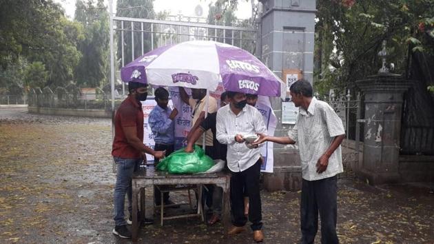 Food packets being distributed by volunteers outside SP College main gate on Tilak road on Wednesday.(HT/PHOTO)