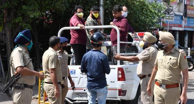 Chandigarh police arresting curfew violators at Sector 22 in Chandigarh on Wednesday.(Keshav Singh/HT)