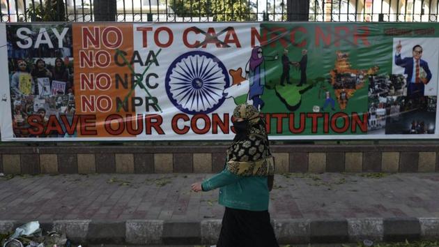 A woman walks near a protest site against against Citizenship Amendment Act (CAA), National Register of Citizens (NRC) and National Population Register, at Jamia Millia Islamia University, in New Delhi on February 14, 2020.(Burhaan Kinu/HT file photo)