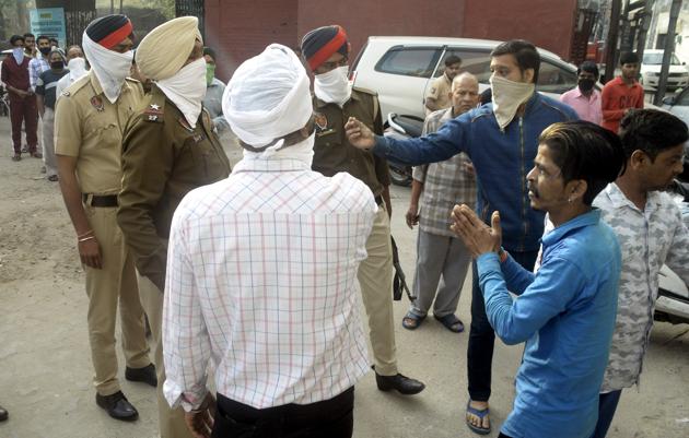 Police dispersing residents huddled outside a flour mill at Chhawani Mohalla in Ludhiana on Thursday.(Gurpreet Singh/HT)