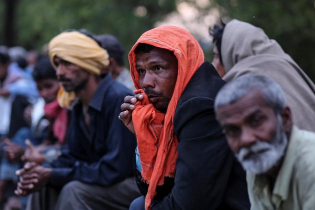 Daily wage workers and homeless people wait for food outside a government-run night shelter during a 21-day nationwide lockdown to limit the spreading of coronavirus disease (COVID-19), in New Delhi.(REUTERS)