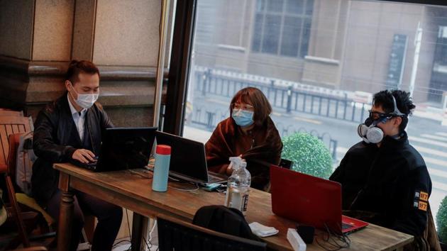 People wear protective masks as they work in a cafe, following an outbreak of the coronavirus disease (COVID-19) in Beijing, China, March 26, 2020. (REUTERS) People wear protective masks as they work in a cafe, following an outbreak of the coronavirus disease (COVID-19) in Beijing, China, March 26, 2020. (REUTERS)