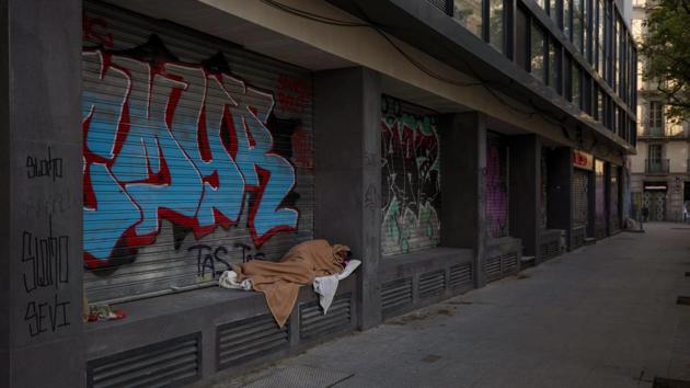 Nasir, 37, from Pakistan, sleeps in an empty street in Barcelona, Spain. Spain, which ranks fourth worldwide among the countries with the most virus cases, is under a government-imposed lockdown that has closed stores, emptied office buildings and left cities largely deserted, day and night. (Emilio Morenatti / AP) Nasir, 37, from Pakistan, sleeps in an empty street in Barcelona, Spain. Spain, which ranks fourth worldwide among the countries with the most virus cases, is under a government-imposed lockdown that has closed stores, emptied office buildings and left cities largely deserted, day and night. (Emilio Morenatti / AP)