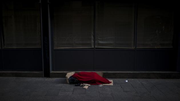 A man covered with a blanket sleeps in an empty street in Barcelona. The sprawling IFEMA exhibition centre in Madrid has been converted into a makeshift shelter with 150 beds. In Barcelona, an old school was turned into a temporary shelter for 56 people, and officials promise to make more beds available soon. (Emilio Morenatti / AP) A man covered with a blanket sleeps in an empty street in Barcelona. The sprawling IFEMA exhibition centre in Madrid has been converted into a makeshift shelter with 150 beds. In Barcelona, an old school was turned into a temporary shelter for 56 people, and officials promise to make more beds available soon. (Emilio Morenatti / AP)
