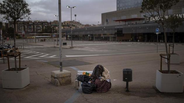 A man from sub-Saharan Africa sits on a bench at an empty car park outside the train station in Barcelona. In typically bustling Barcelona, figures with boxes and blankets, mattresses or tents, punctuate the eerie emptiness. The bare sidewalks and doorways of shuttered shops where they bed down during a national health emergency accentuate the isolation of the city’s homeless population, of about 1,000. (Emilio Morenatti / AP) A man from sub-Saharan Africa sits on a bench at an empty car park outside the train station in Barcelona. In typically bustling Barcelona, figures with boxes and blankets, mattresses or tents, punctuate the eerie emptiness. The bare sidewalks and doorways of shuttered shops where they bed down during a national health emergency accentuate the isolation of the city’s homeless population, of about 1,000. (Emilio Morenatti / AP)