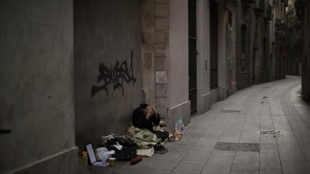 Javier Redondo, 40, covers his head with his hands as he waits for alms on an empty street in Barcelona. Many of the city’s day centres for the homeless and soup kitchens have closed or reduced their hours during the lockdown. “I am not afraid of the virus because my physical condition is very good. If I caught the virus, my body would expel it as if it were a gastroenteritis”, Javier said. (Emilio Morenatti / AP) Javier Redondo, 40, covers his head with his hands as he waits for alms on an empty street in Barcelona. Many of the city’s day centres for the homeless and soup kitchens have closed or reduced their hours during the lockdown. “I am not afraid of the virus because my physical condition is very good. If I caught the virus, my body would expel it as if it were a gastroenteritis”, Javier said. (Emilio Morenatti / AP)