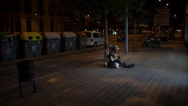 Kevin, 32, from France, plays guitar in front of a supermarket in Barcelona. Kevin, who has slept on the streets of Barcelona for the last 4 years said “I used to earn enough money to eat every day, now I don't get even one meal a day. Now I play the guitar just for me as nobody is in the street.” (Emilio Morenatti / AP) Kevin, 32, from France, plays guitar in front of a supermarket in Barcelona. Kevin, who has slept on the streets of Barcelona for the last 4 years said “I used to earn enough money to eat every day, now I don't get even one meal a day. Now I play the guitar just for me as nobody is in the street.” (Emilio Morenatti / AP)