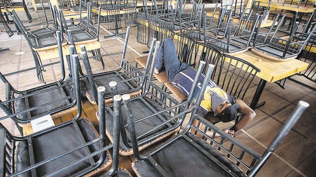 A worker is seen sleeping in a shut restaurant near Mhatre bridge on Thursday. According to officials, a reason for the decline in milk demand is because it was majorly supplied to tea stalls, restaurants and sweet shops that are closed due to the lockdown. (Pratham Gokhale/HT Photo) A worker is seen sleeping in a shut restaurant near Mhatre bridge on Thursday. According to officials, a reason for the decline in milk demand is because it was majorly supplied to tea stalls, restaurants and sweet shops that are closed due to the lockdown. (Pratham Gokhale/HT Photo)