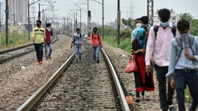 Migrant workers walk on railway tracks in Ghaziabad. Many migrants on the move have faced harassment from the police. Videos and television visuals from across India showed workers being allegedly forced to crawl on roads, made to do sit-ups and kneel down on the side of highways. (Arun Sharma / PTI)