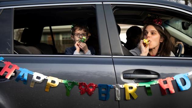 Dana Baer and her son Jacob Baer wish Avery Slutsky a happy sixth birthday from their car during a drive-by birthday celebration as they maintain social distance amid an outbreak of coronavirus across the country in West Bloomfield Township, Michigan, United States. (Emily Elconin / REUTERS) Dana Baer and her son Jacob Baer wish Avery Slutsky a happy sixth birthday from their car during a drive-by birthday celebration as they maintain social distance amid an outbreak of coronavirus across the country in West Bloomfield Township, Michigan, United States. (Emily Elconin / REUTERS)