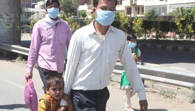 Migrant worker have borne the brunt of the lockdown as they try to reach their homes. A worker with his child stranded at IFFCO chowk, Gurugram.(Yogendra Kumar/Hindustan Times)