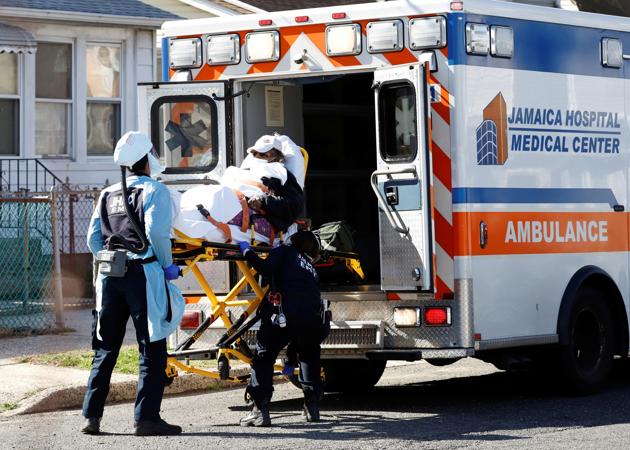 Emergency Medical Technicians (EMT) lift a patient into an ambulance while wearing protective gear, as the outbreak of coronavirus disease (COVID-19) continues, in New York City.(REUTERS)