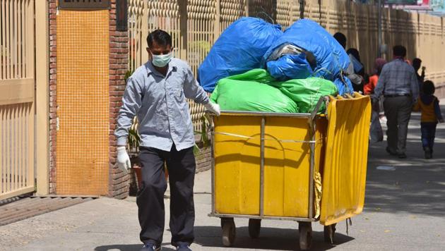 Coronavirus update: A hospital staff hauling a waste disposal trollley, at Lok Nayak hospital. (Sanchit Khanna/HT PHOTO) Coronavirus update: A hospital staff hauling a waste disposal trollley, at Lok Nayak hospital. (Sanchit Khanna/HT PHOTO)