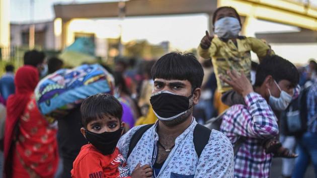 Ashok Kumar Pandey,29, a security guard, with his 2 year old son, while walking to Gonda in UP from Ashram, New Delhi on March 28, 2020, after a 21-day national lockdown was imposed by Prime Minister Narendra Modi to curb the spread of coronavirus. (Biplov Bhuyan/HT PHOTO) Ashok Kumar Pandey,29, a security guard, with his 2 year old son, while walking to Gonda in UP from Ashram, New Delhi on March 28, 2020, after a 21-day national lockdown was imposed by Prime Minister Narendra Modi to curb the spread of coronavirus. (Biplov Bhuyan/HT PHOTO)