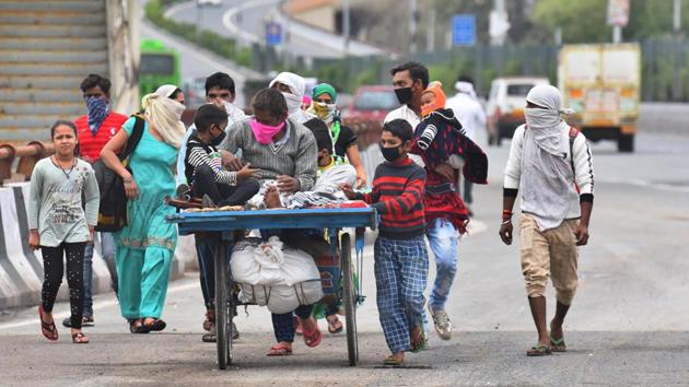 Ram Avatar, a migrant worker is seen on a hand push cart with his family as they make their way home to Sambhal district in Uttar Pradesh during the 21-day national lockdown at NH24, in New Delhi. (Raj K Raj / HT Photo)
