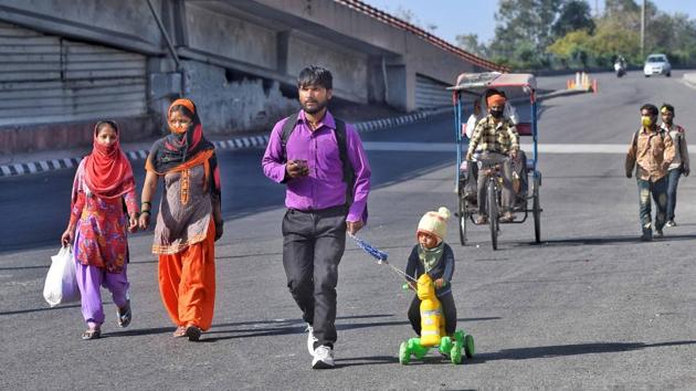 Ranjit Rajput, 28, a migrant worker from Bareilly walks back to his hometown with his son Prince, 4, on Saturday, March 28. (Biplov Bhuyan / HT Photo)