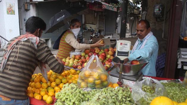 People buying fruits from a vendor at Gurugram’s Sadar Bazar sabzi mandi on the third day of the national lockdown to curb the spread of coronavirus.(Yogendra Kumar/HT PHOTO)