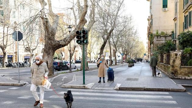 Coronavirus update: Pedestrians wearing protective face masks cross a road in Rome, Italy on Friday. (Bloomberg) Coronavirus update: Pedestrians wearing protective face masks cross a road in Rome, Italy on Friday. (Bloomberg)