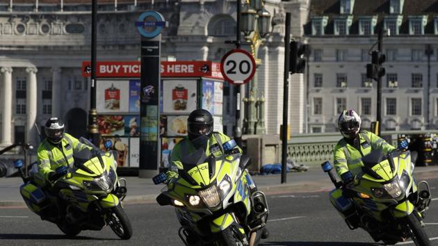 Police motorcycle outriders with lights flashing turn onto Westminster Bridge in London. (AP) Police motorcycle outriders with lights flashing turn onto Westminster Bridge in London. (AP)