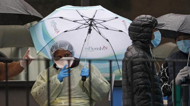 A medical worker points out the COVID-19 testing tent set up outside Elmhurst Hospital Center in New York.(AP Photo)