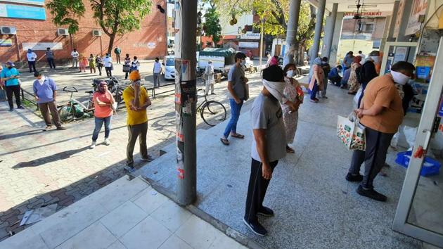 Residents waiting at a safe distance from each other outside a shop in Sector 44.(KESHAV SINGH/ HT)