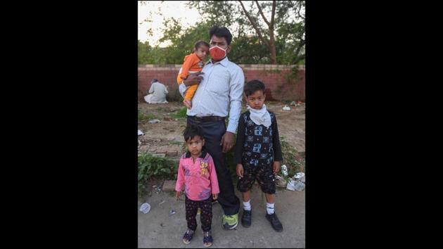 Vijay, 30, a tailor, with his three children while walking to Badaun in UP from Ashram, New Delhi. He said he had 500 rupees to make the journey. (Biplov Bhuyan / HT Photo) Vijay, 30, a tailor, with his three children while walking to Badaun in UP from Ashram, New Delhi. He said he had 500 rupees to make the journey. (Biplov Bhuyan / HT Photo)