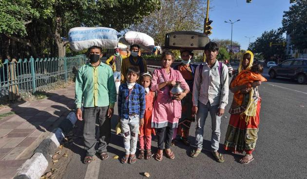 A group of migrants pose for a picture while walking from Delhi, after national lockdown imposed by Prime Minister Narendra Modi to curb the spread of coronavirus, at Ashram, Delhi, India, on Saturday, March 28, 2020.(Biplov Bhuyan/HT photo)