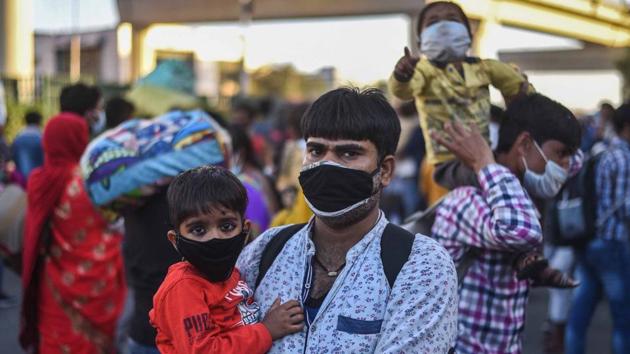 Ashok Kumar Pandey, 29, a security guard, with his two year--old son, while walking to Gonda in UP from Ashram, New Delhi on March 28. (Biplov Bhuyan / HT Photo) Ashok Kumar Pandey, 29, a security guard, with his two year--old son, while walking to Gonda in UP from Ashram, New Delhi on March 28. (Biplov Bhuyan / HT Photo)