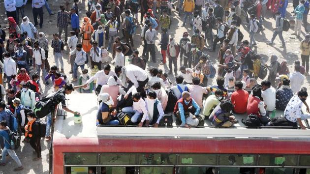Migrant workers rush to board buses arranged by the Uttar Pradesh government, with many riding on the roofs, on day five of the nationwide lockdown to check the spread of coronavirus, at Lal Kuan Bus Stand in Ghaziabad, India, on Sunday, March 29, 2020. (Ajay Aggarwal / HT Photo) Migrant workers rush to board buses arranged by the Uttar Pradesh government, with many riding on the roofs, on day five of the nationwide lockdown to check the spread of coronavirus, at Lal Kuan Bus Stand in Ghaziabad, India, on Sunday, March 29, 2020. (Ajay Aggarwal / HT Photo)