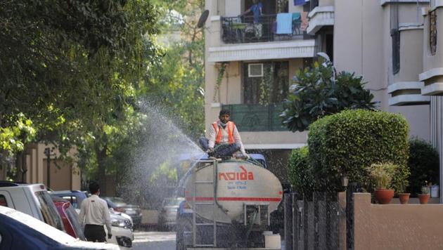 A Noida Authority health department worker disinfects an area during a sanitization drive, on day 4 of the nationwide lockdown to check the spread of coronavirus.(Sunil Ghosh /HT Photo)