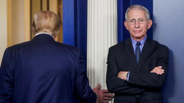 US President Donald Trump departs after addressing the coronavirus task force daily briefing as Dr. Anthony Fauci, director of the National Institute of Allergy and Infectious Diseases, stands by at the White House in Washington.(REUTERS)