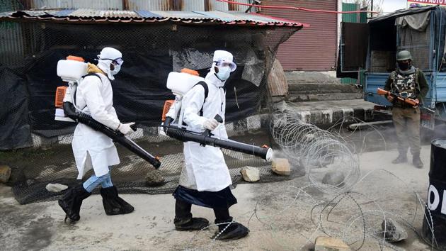 Srinagar Municipal Corporation (SMC) workers spray disinfectant at a security force bunker after four more cases of coronavirus detected in Srinagar. (ANI) Srinagar Municipal Corporation (SMC) workers spray disinfectant at a security force bunker after four more cases of coronavirus detected in Srinagar. (ANI)