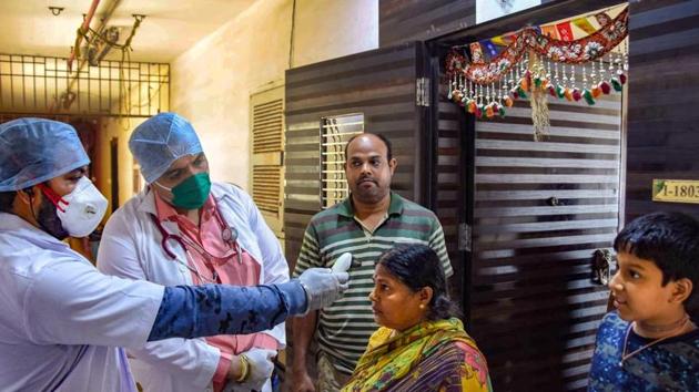 Medics from Rs 1 clinic conduct a door-to-door thermal screening of residents, during a nationwide lockdown, imposed in the wake of coronavirus pandemic, in Mumbai on March 29, 2020.(PTI file photo)