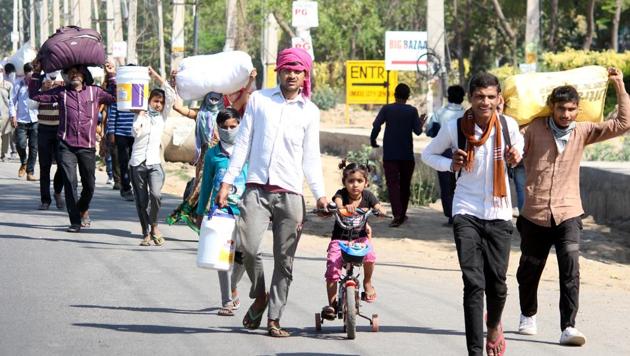 Migrant workers and their families head to their home towns and villages on foot on Sunday.(Yogendra Kumar/HT PHOTO)