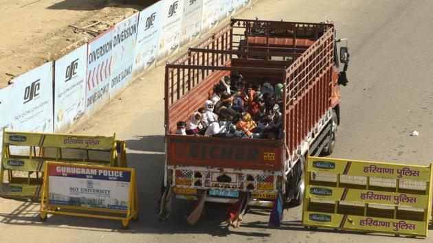 Migrant workers head home in a goods truck at the Gurugram-Alwar national highway, NH 248, near Tau Devilal Stadium, Sector-38, in Gurugram. (Parveen Kumar / HT Photo)