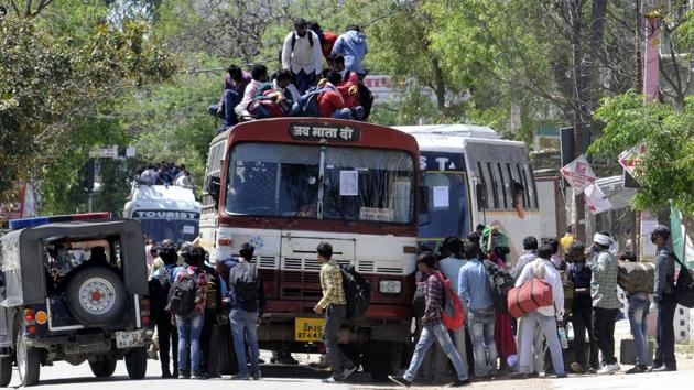 Migrant workers try to board an overcrowded bus to return to their home on day 5 of the 21-day nationwide lockdown to curb the spread of coronavirus.(Dheeraj Dhawan/HT Photo)