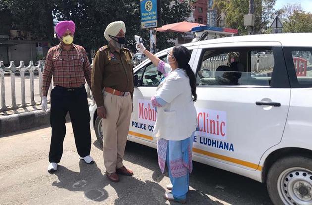 A doctor checking the temperature of policeman in Ludhiana.(ht photo)