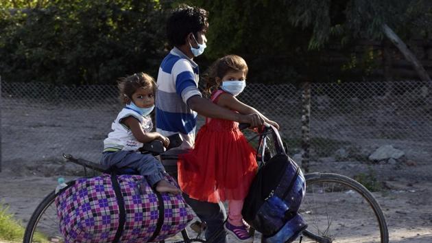 A migrant worker and family heads home on Day 5 of the 21 day nationwide lockdown imposed by PM Narendra Modi to curb the spread of coronavirus, at Greater Noida Expressway, in Noida, India, on Sunday, March 29, 2020.(Mohd Zakir/Hindustan Times photo)