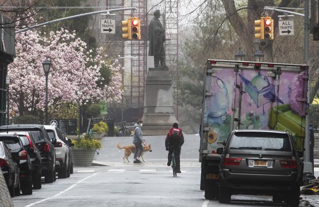 A cyclist and a dog walker are seen along West 16th Street near Union Square, Sunday, March 29, 2020, in New York.(AP)
