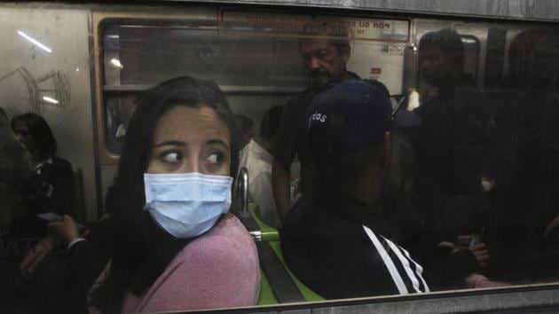 A commuter in the metro wears a protective mask as a precaution against the spread of the new coronavirus in Mexico City. More than 720,000 people have been infected across the world and over 33,000 have died as of March 30. (Marco Ugarte / AP) 
