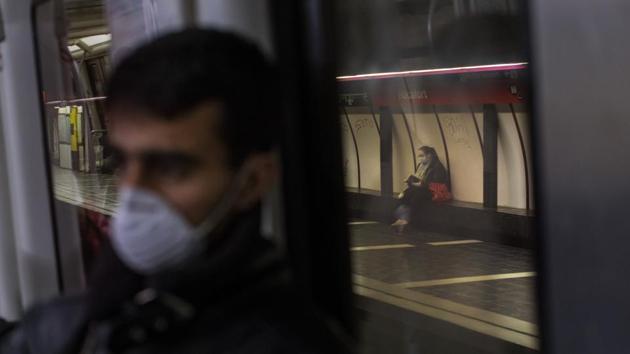 A man wearing a face mask travels by train in Barcelona. Globally, over 145,000 cases have been reportedly cured, around 20%. With no certain cure for Covid-19 and vaccines in the distance, personal hygiene and social distancing remain essential measures to avoiding infection. (Emilio Morenatti / AP) 