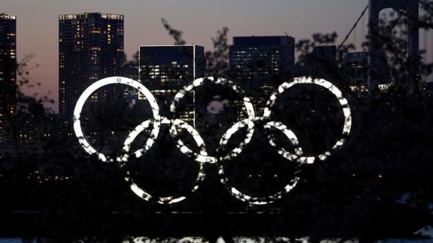 The giant Olympic rings are seen in the dusk through a tree at the waterfront area at Odaiba Marine Park after postponing Games due to the outbreak of coronavirus disease (COVID 19), in Tokyo, Japan March 25, 2020.(REUTERS)