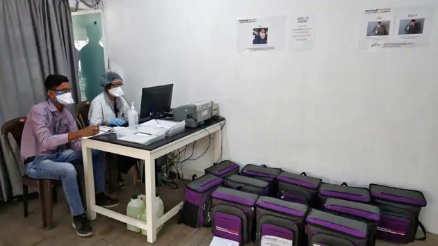 Laboratory technicians sit next to boxes containing coronavirus disease (COVID-19) testing kits at a sample collection centre in Ahmedabad. (Reuters) Laboratory technicians sit next to boxes containing coronavirus disease (COVID-19) testing kits at a sample collection centre in Ahmedabad. (Reuters)